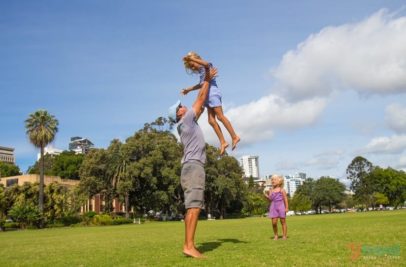 Craig throwing kayra into air as savannah watches on perth foreshore park