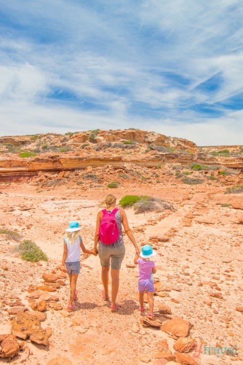 Caroline holding savanaah and kalyra's hands holding hands walking on a dirt trail