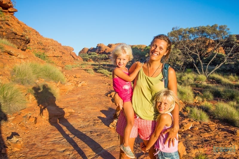 woman holding her children on a hiking trail