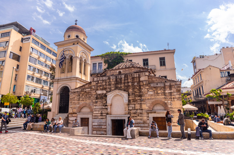 people sitting outside the stone Panagia Pantanassa church athens