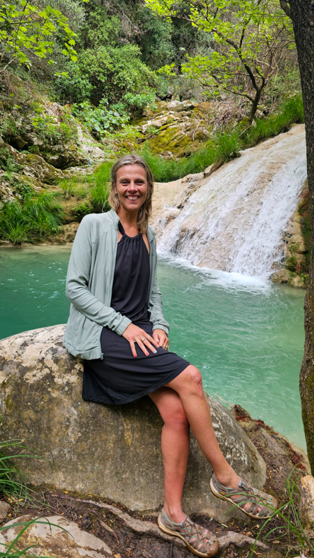 caz sitting in front of small waterfall