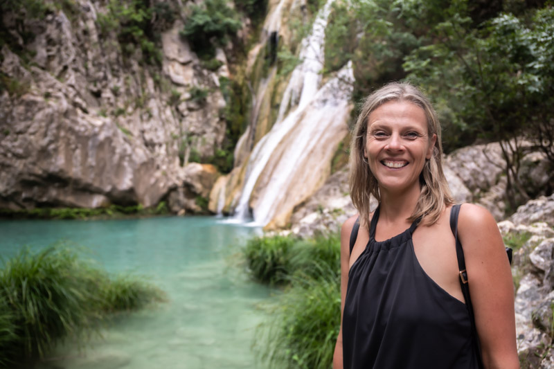 caz smiling at camera in front of waterfall