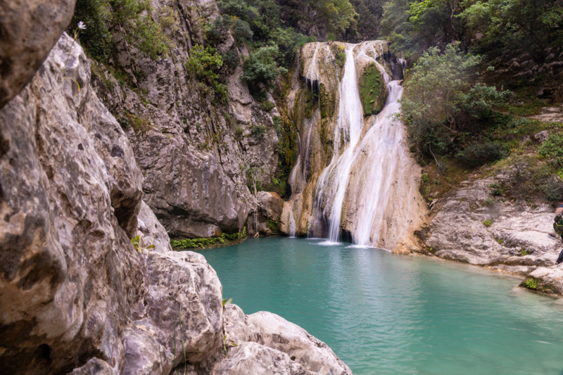 Polylimnio Waterfall dropping into pool of water