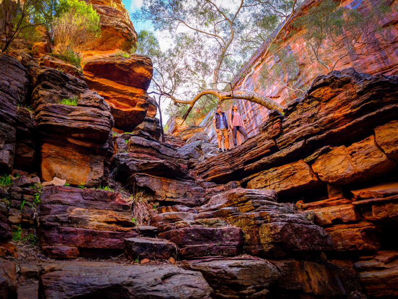 hikers on the Z Bend River Trail surrounded by red jagged rock