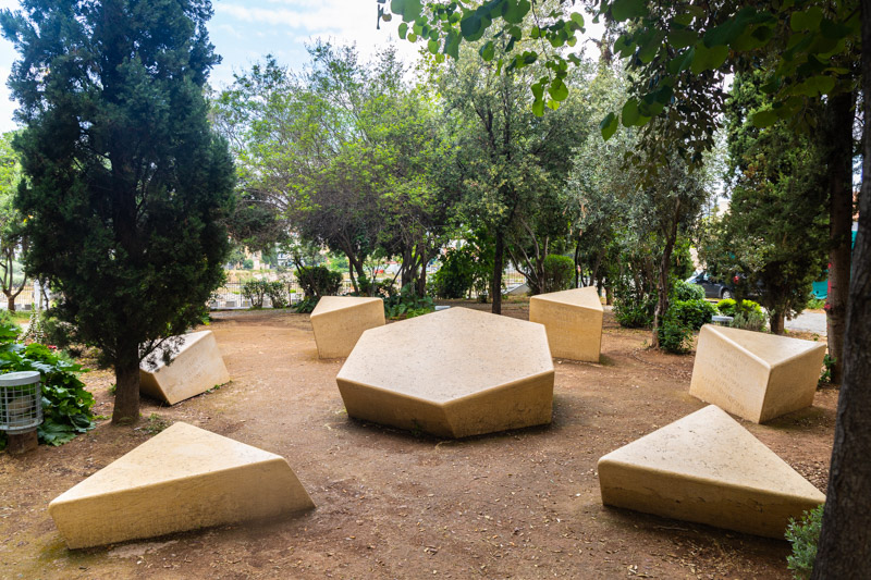 star of david broken into separate shapes on ground surrounded by trees