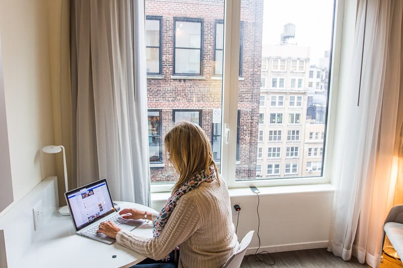 woman sitting at hotel desk on computer