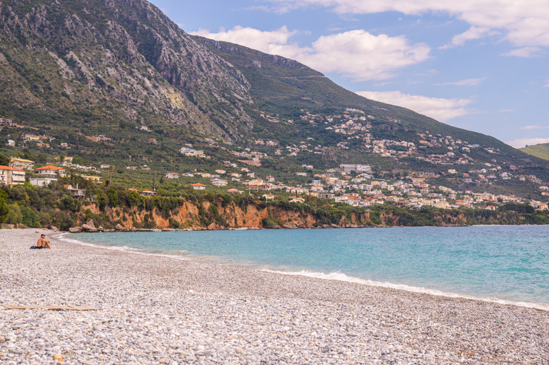 person sitting on rocky kalamata beach