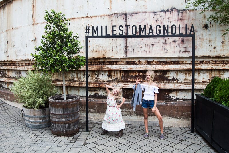 kalyra and savannah posing under miles to magnolia sign