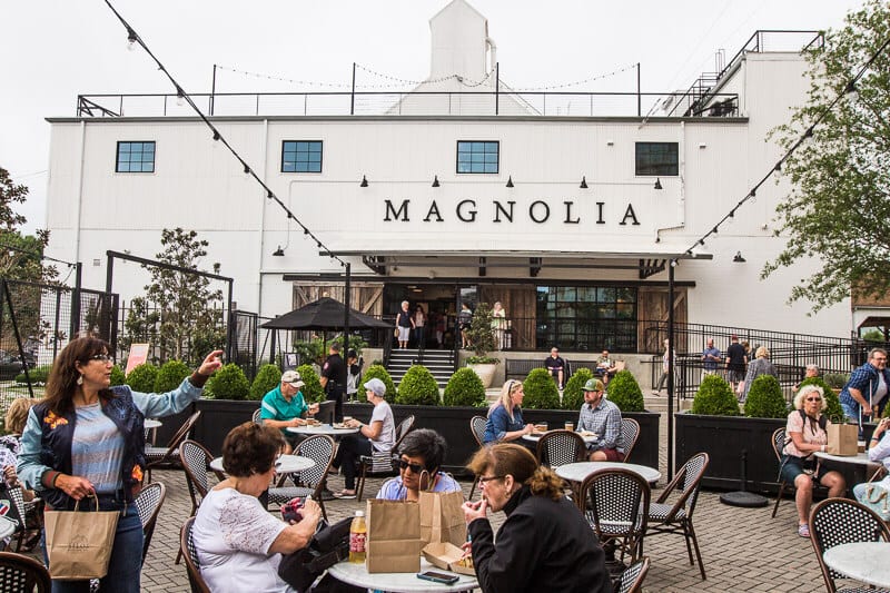 people sitting at tables outside a cafe