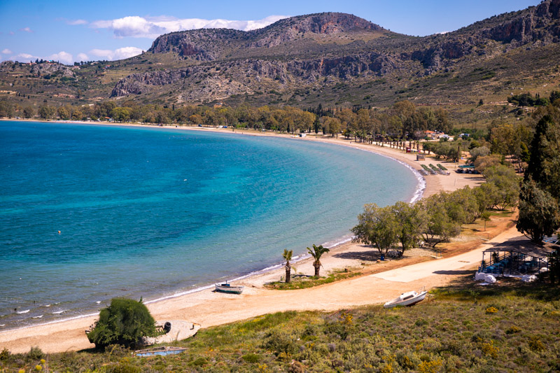 aerial view of curving Kondyli Beach  with mountains in the background