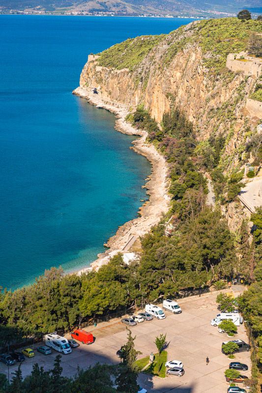 clear blue waters on the coastline at the bottom of cliff faces