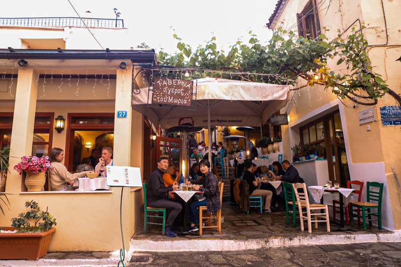 people sitting outside restaurant on the stairs