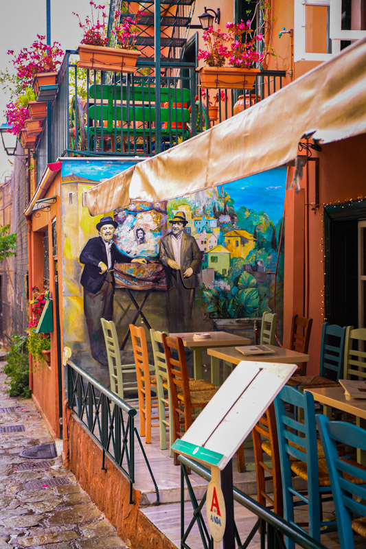 tables outside restaurant with colorful wall murals