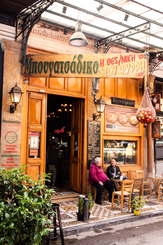 two men sitting outside bar in psyrri