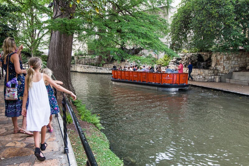 caz and girls looking at red boat go by on san anotnio river