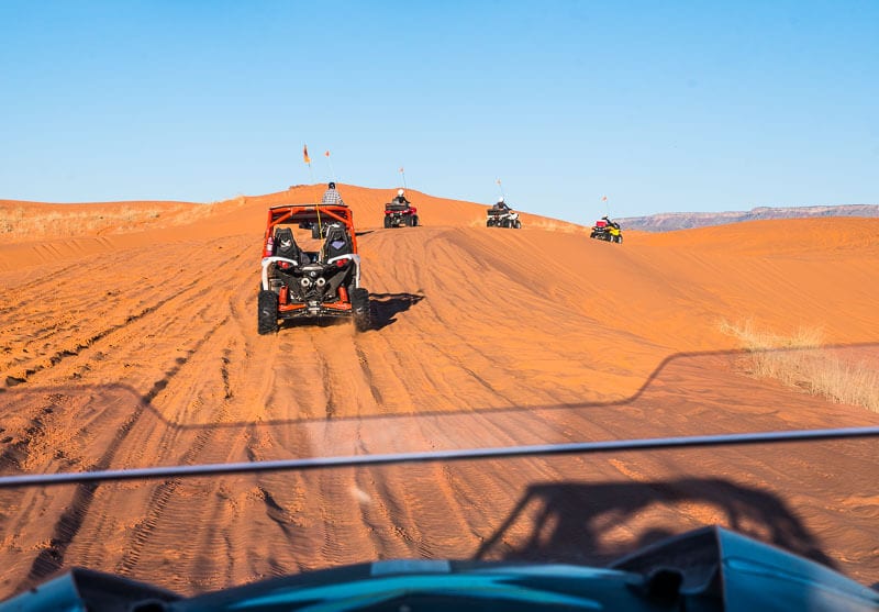 atv  racing across dunes