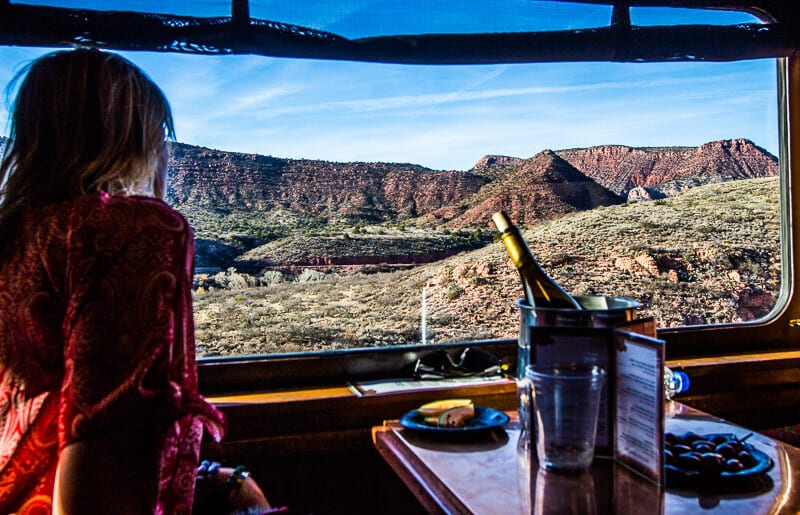 woman looking out train window at red canyon landsscape