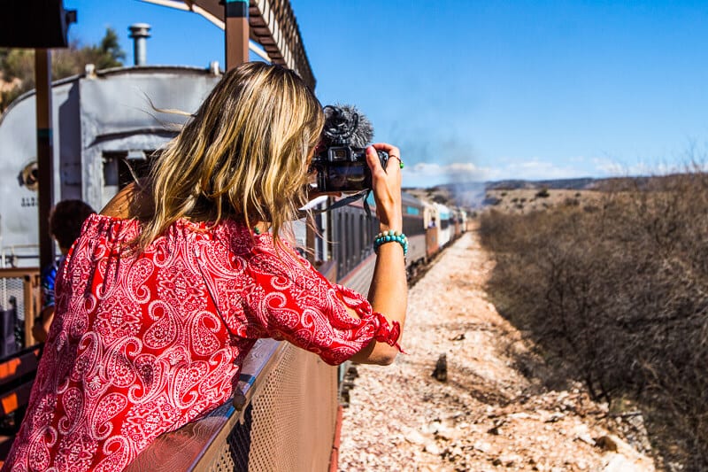 caz leaning out of a train window