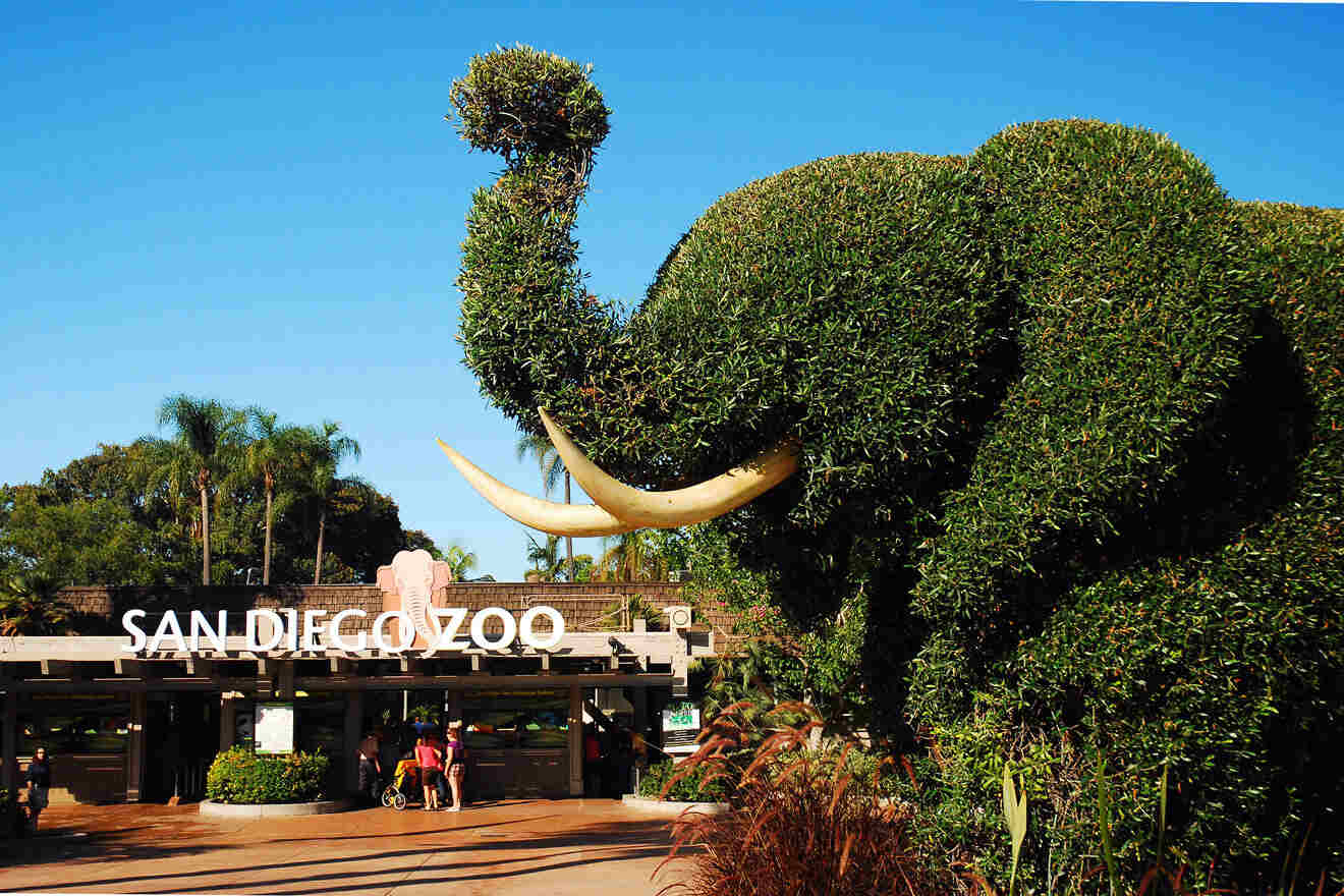 a large elephant made out of topiary in front of a zoo