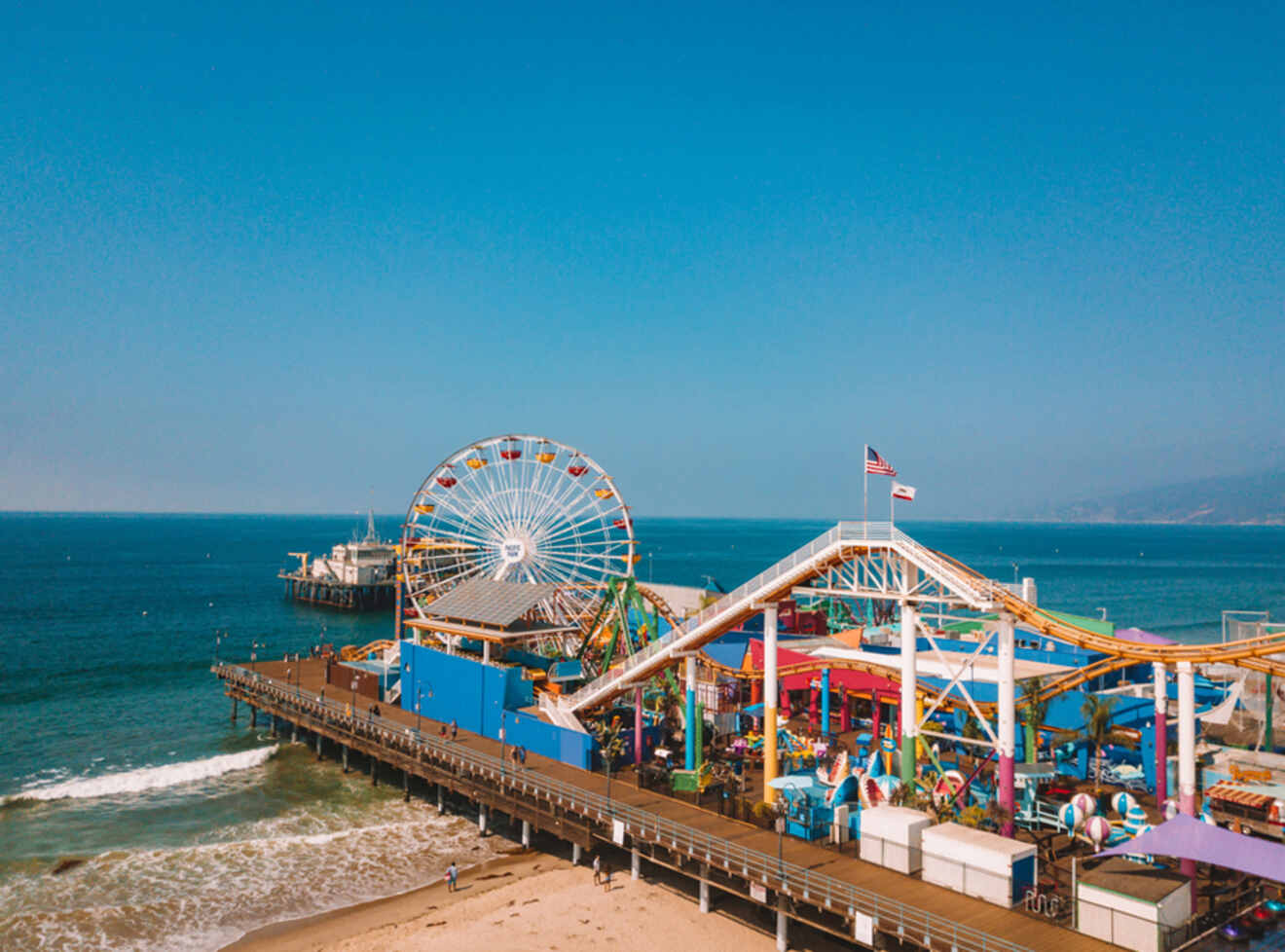 a ferris wheel on a pier next to the ocean