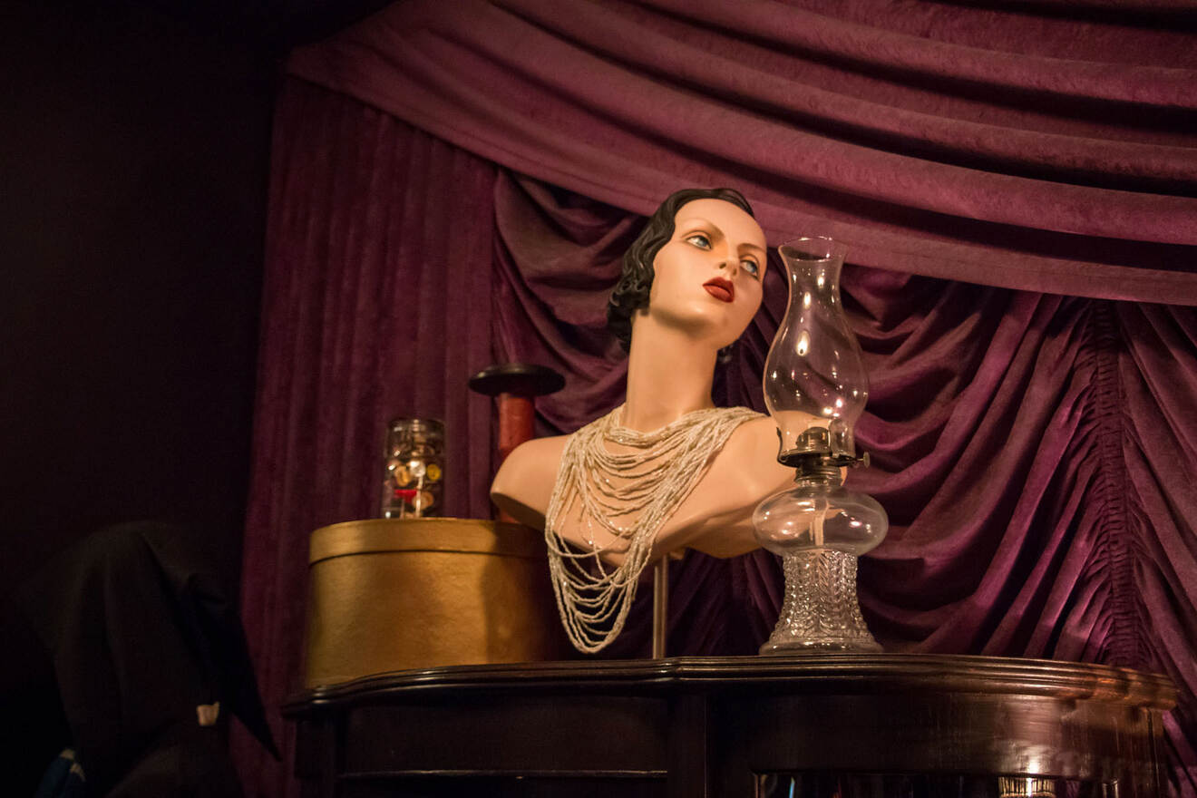 A mannequin of women with old lamp on top of a table