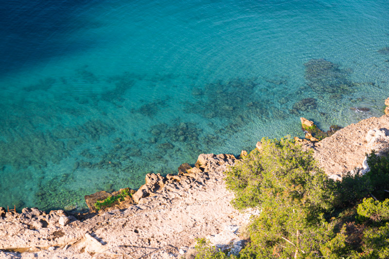 crystal clear water beside rocky coastline