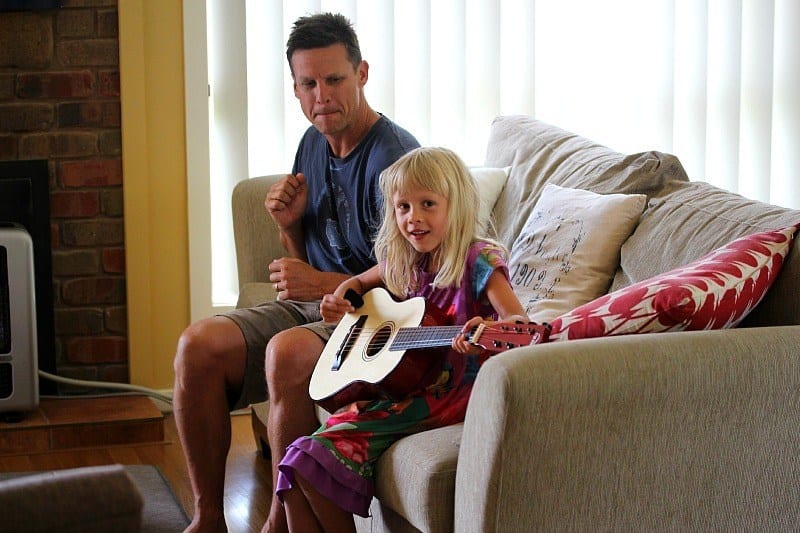 craig and savannah playing guitar on couch  our house-sit in Bright, Victoria