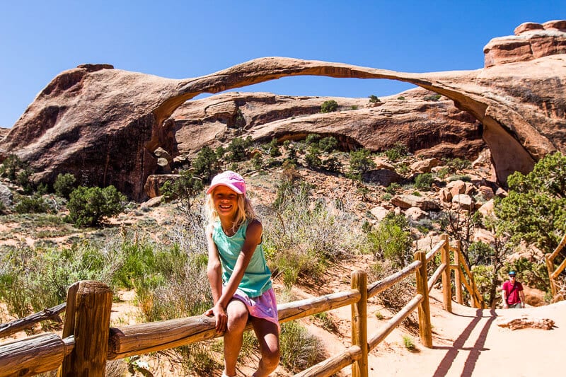 savannah posing under landscape Arch in Arches National Park, Utah