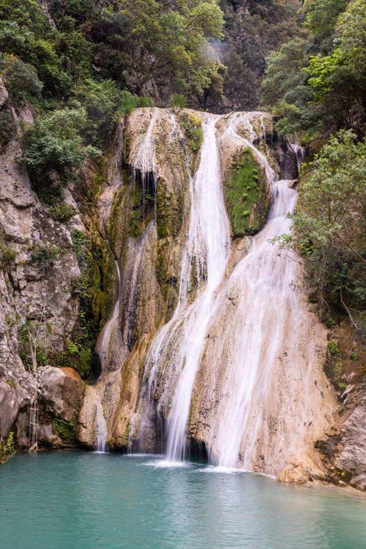 waterfall tumbling over a steep cliff face into a pool of water