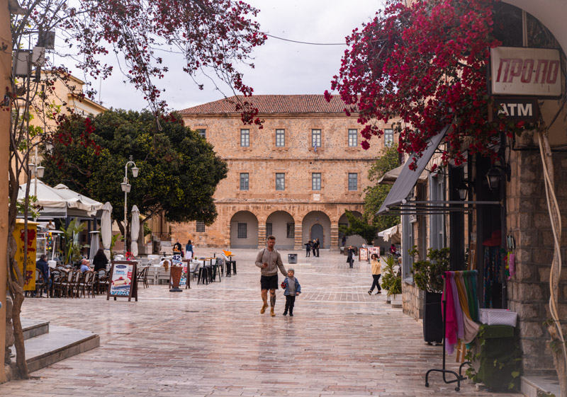 man and child walking through syntagma square