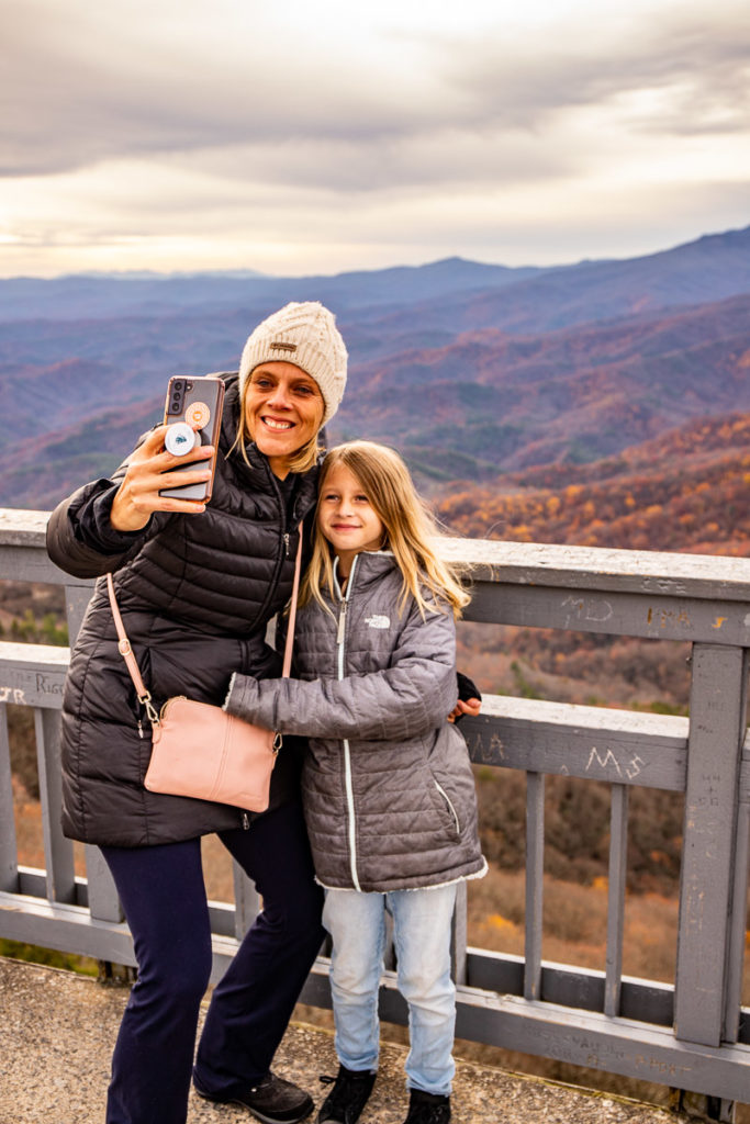 people posing for a selfie on a bridge