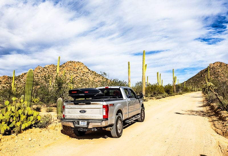 truck on dirt road next to cactus 