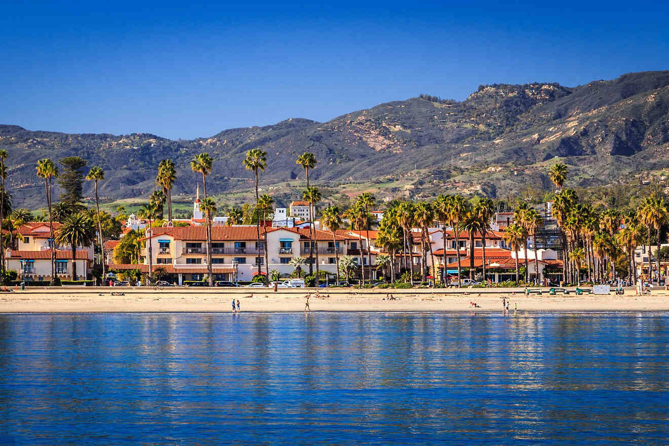 a beach with palm trees and a hotel in the background