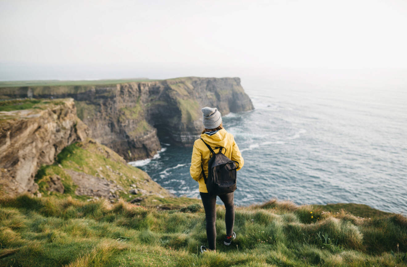 a person standing on a cliff overlooking the ocean