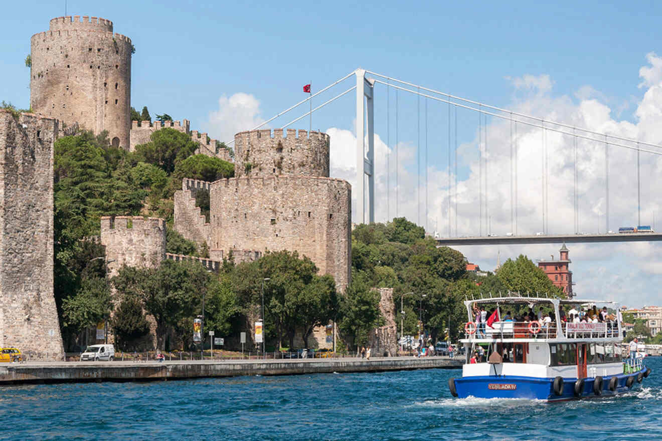 a boat traveling down a river near a bridge and a castle