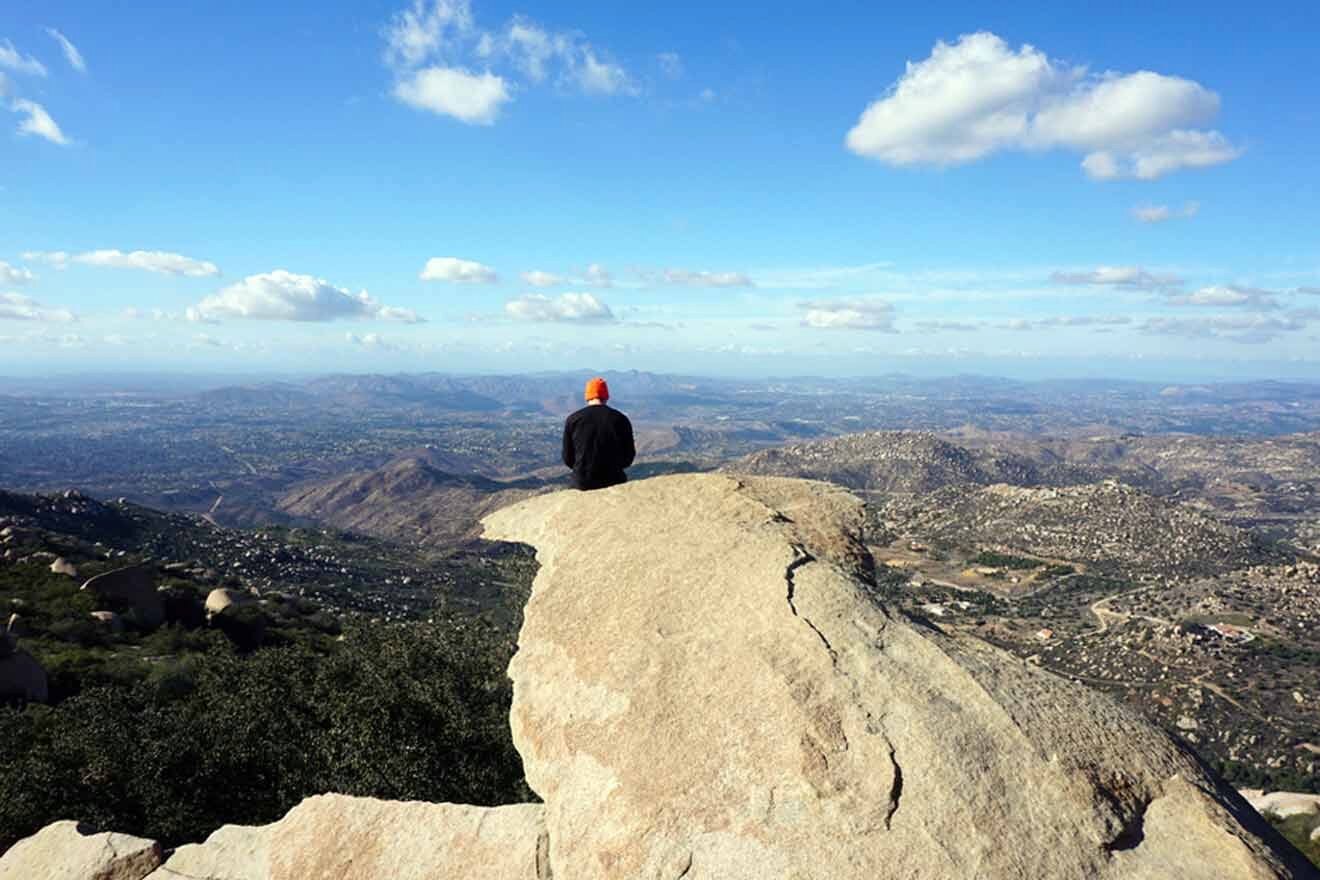 a person sitting on top of a large rock