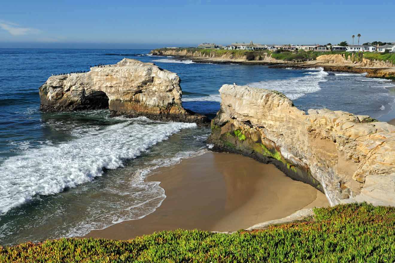 a view of a beach with rock formations and waves coming in from the ocean