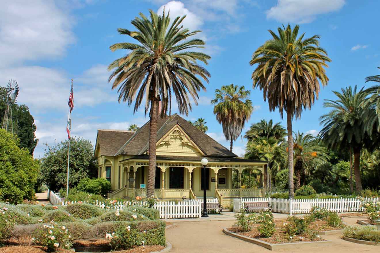 a small yellow house with palm trees in front of it