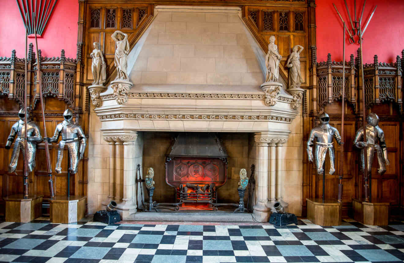 a room with a fireplace and statues on the wall