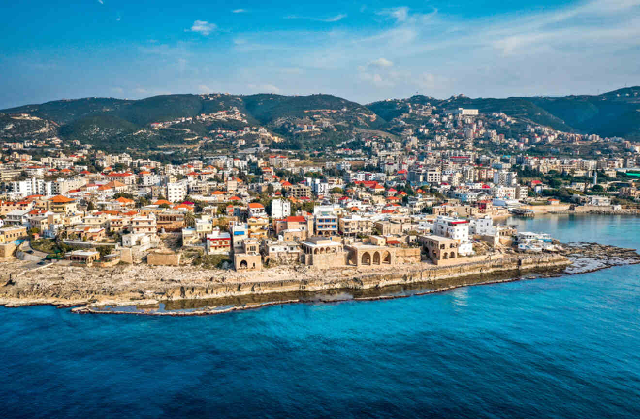 Drone shot of the Mediterranean sea coast showing an old city and the Phoenician wall