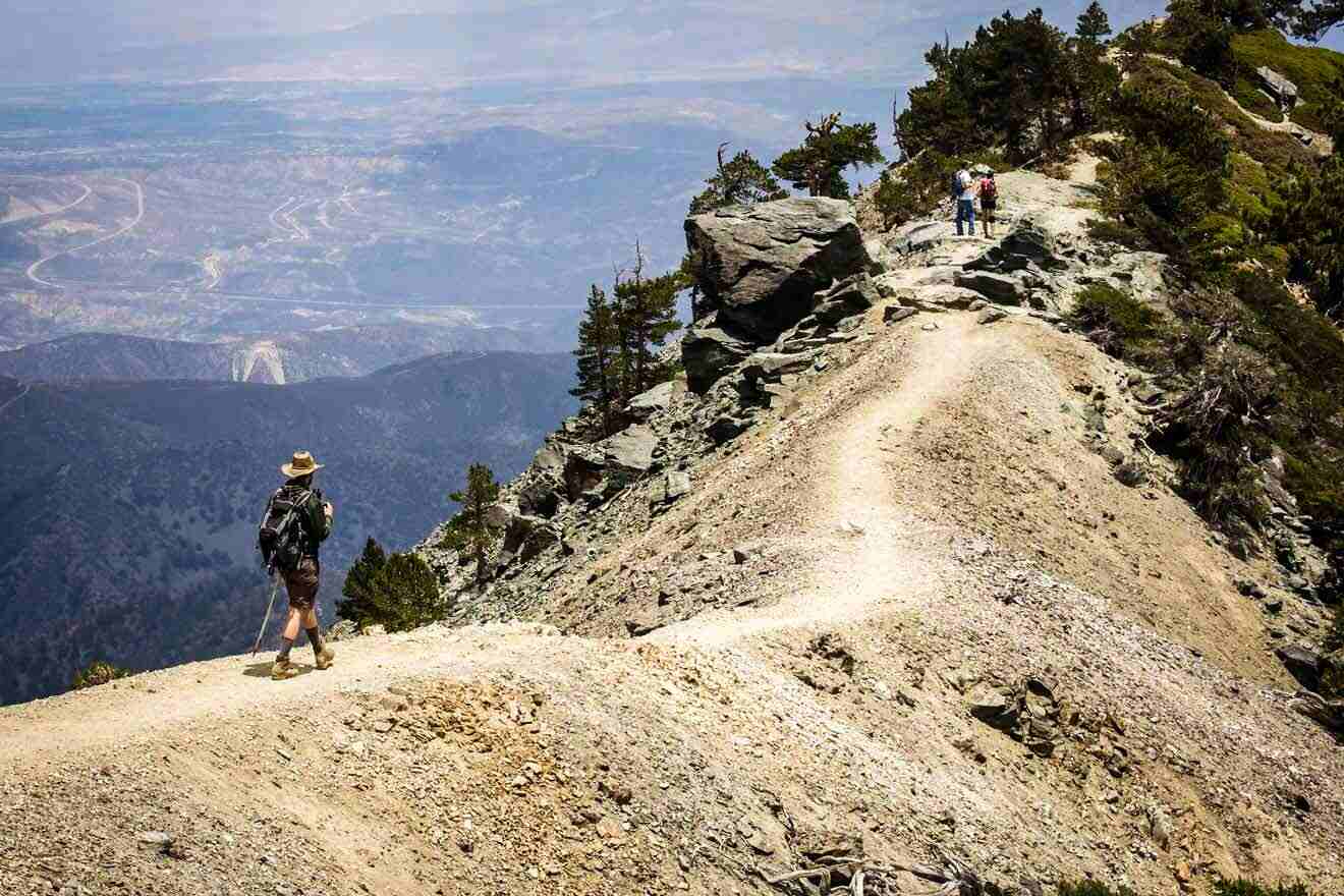 people hiking up a mountain with backpacks