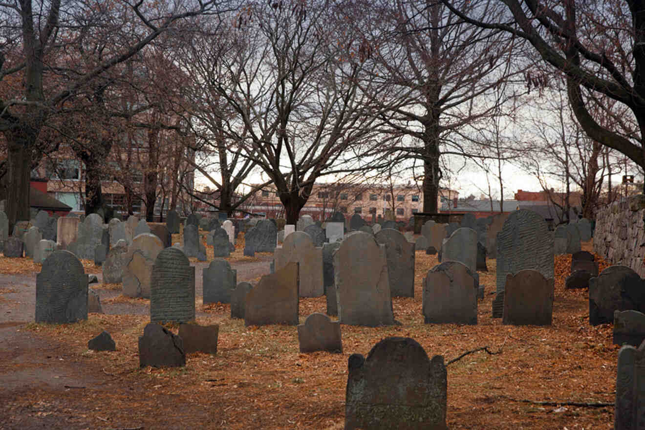 a cemetery with headstones and trees in the background