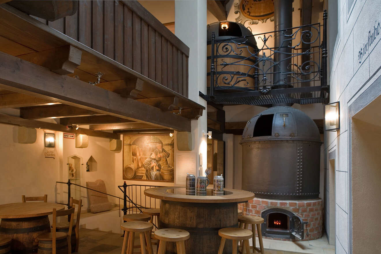 a room with a table, stools and a fireplace