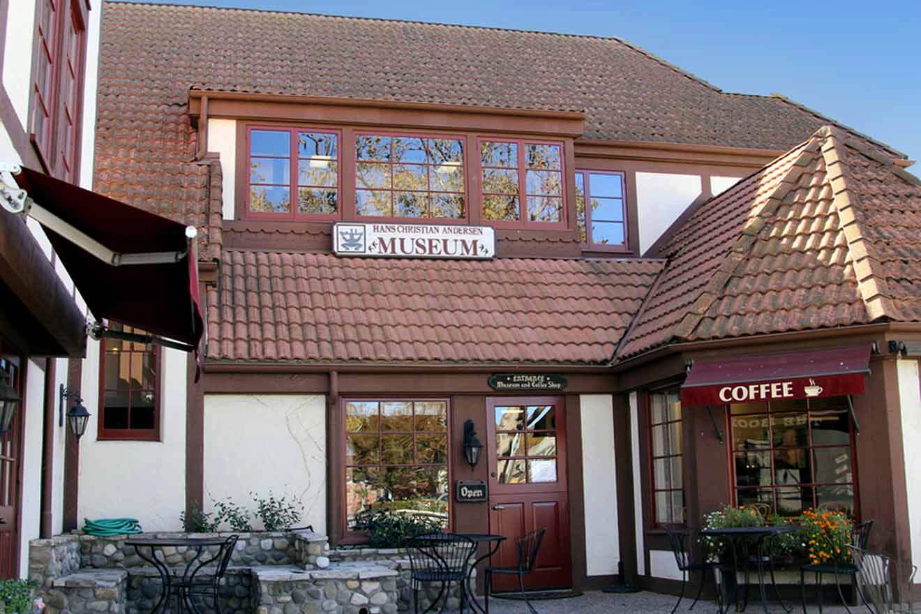 a building which houses a museum and a coffee shop with tables and chairs in front of it