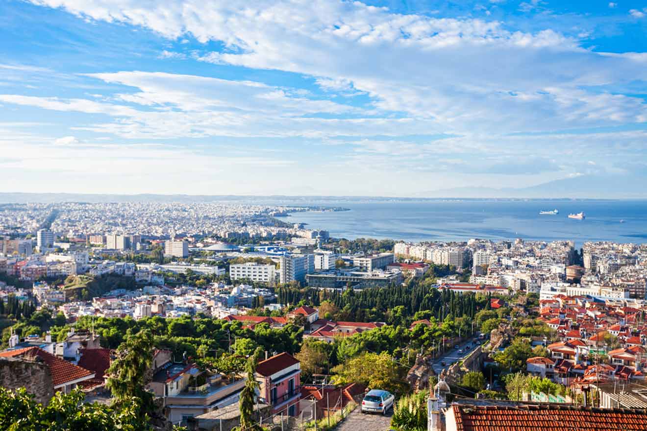 a view of a city and the sea from a hill