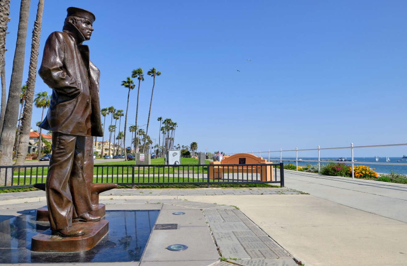 a statue of a man standing next to the ocean