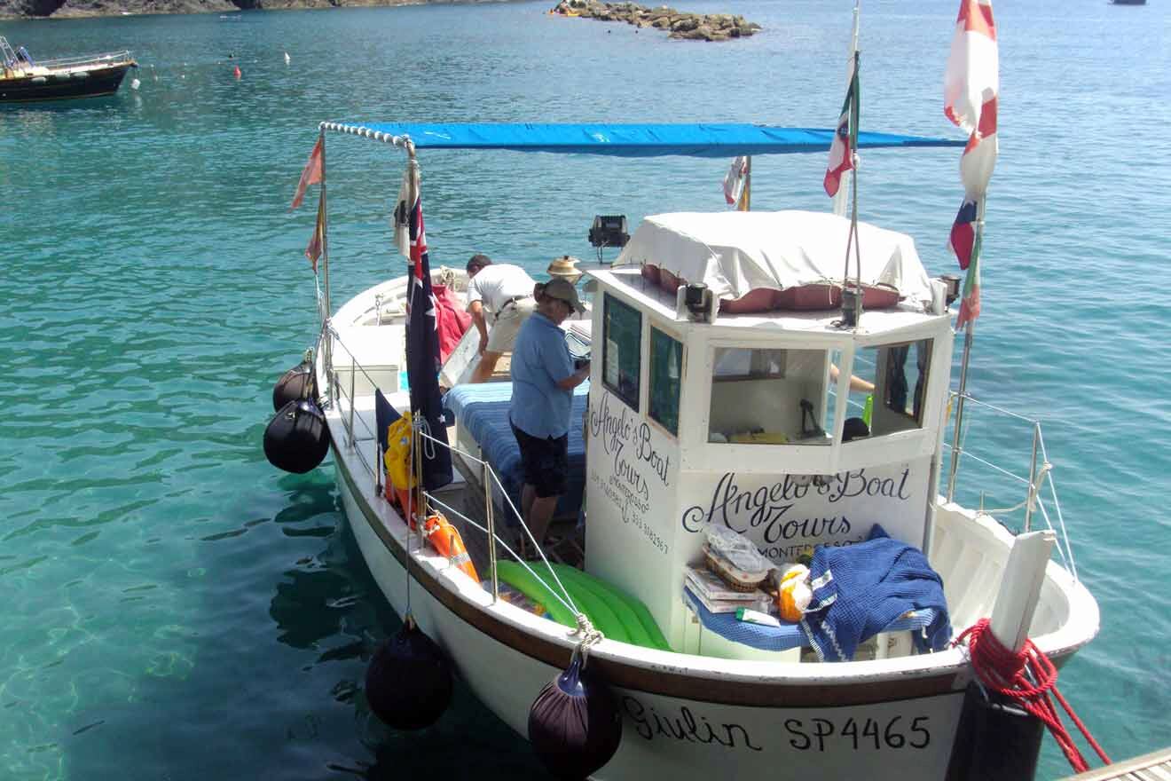 two people standing on top of a boat in the water