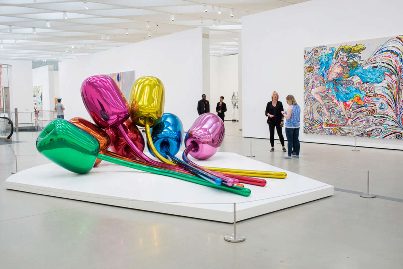 a group of people near art object in a museum