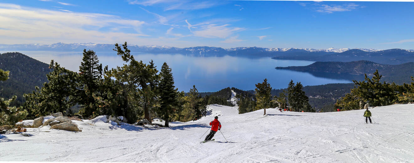 View of people skiing on a mountain view a view over lake