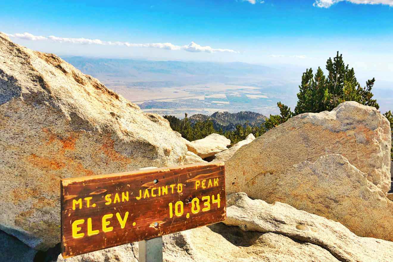 a wooden sign sitting on the side of a mountain